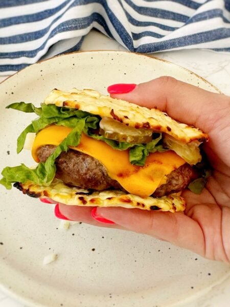 Cottage cheese Big Mac held in one hand showing the baked cottage cheese buns