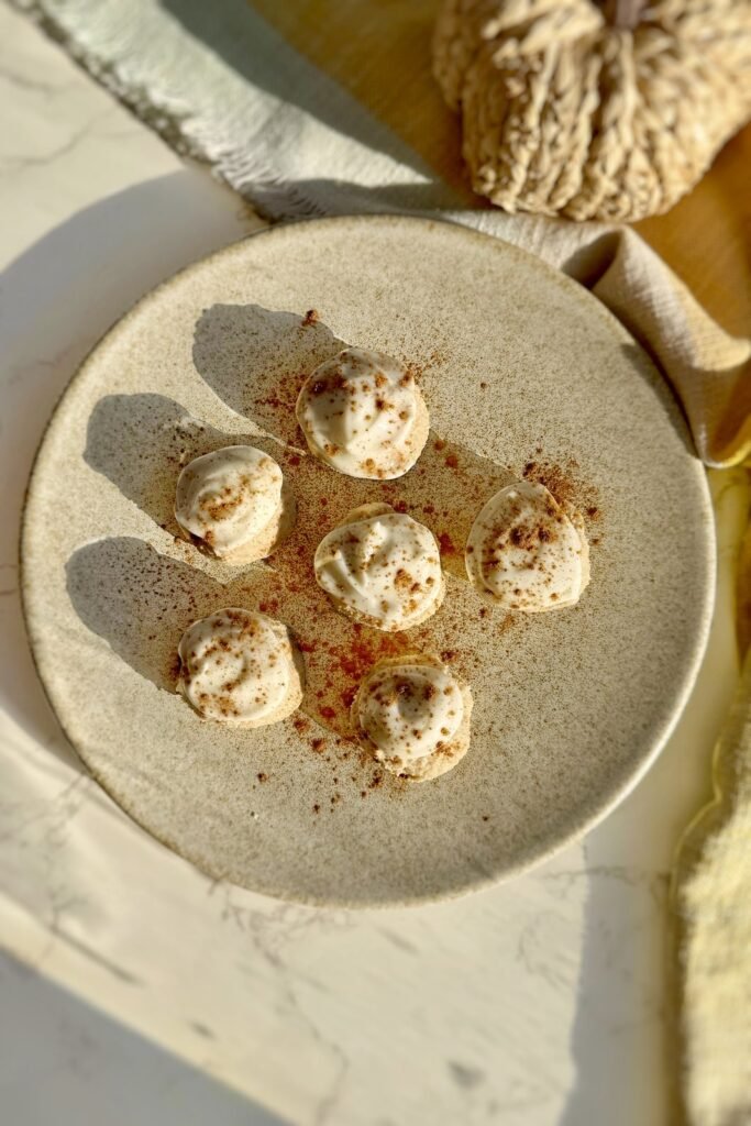 Batch of pumpkin spice cheesecake bites arranged on a speckled plate