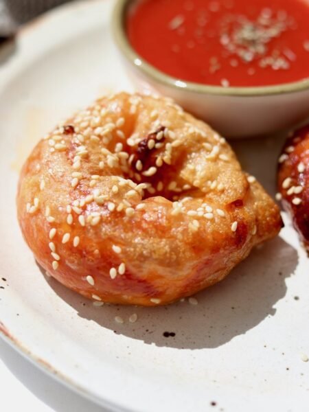 Rice paper pizza bagels on a plate with a bowl of passata dipping sauce