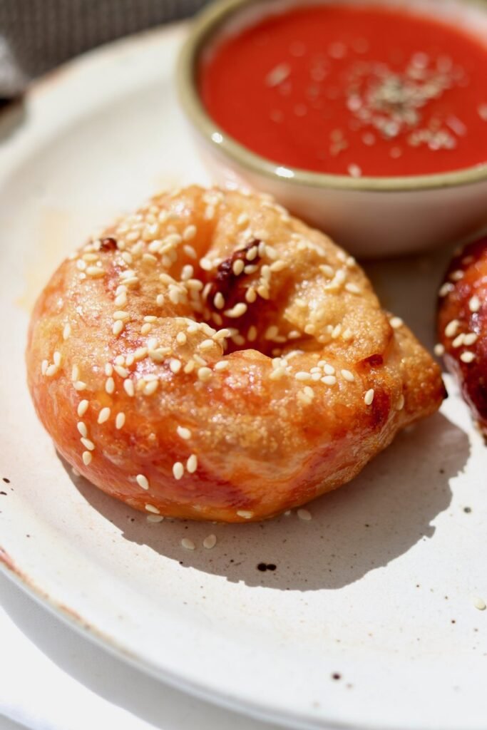 Rice paper pizza bagels on a plate with a bowl of passata dipping sauce