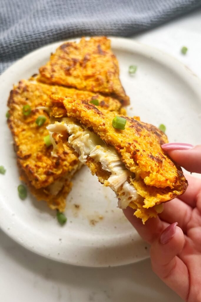 Sweet potato wrap cut in half showing the chicken and melted cheese filling