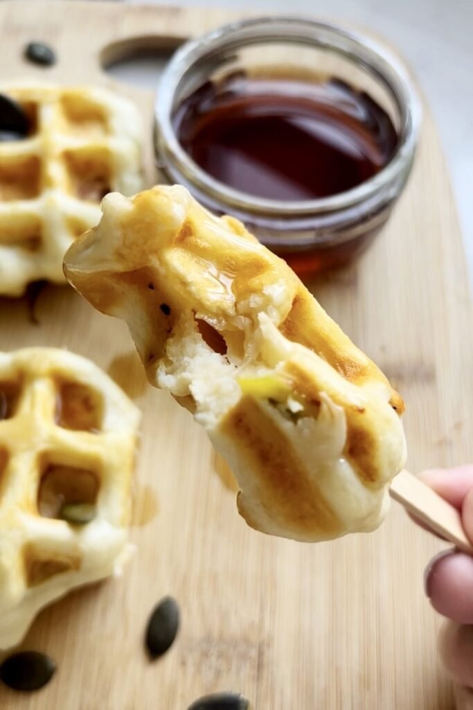 A bitten apple waffle pop showing the soft apple inside