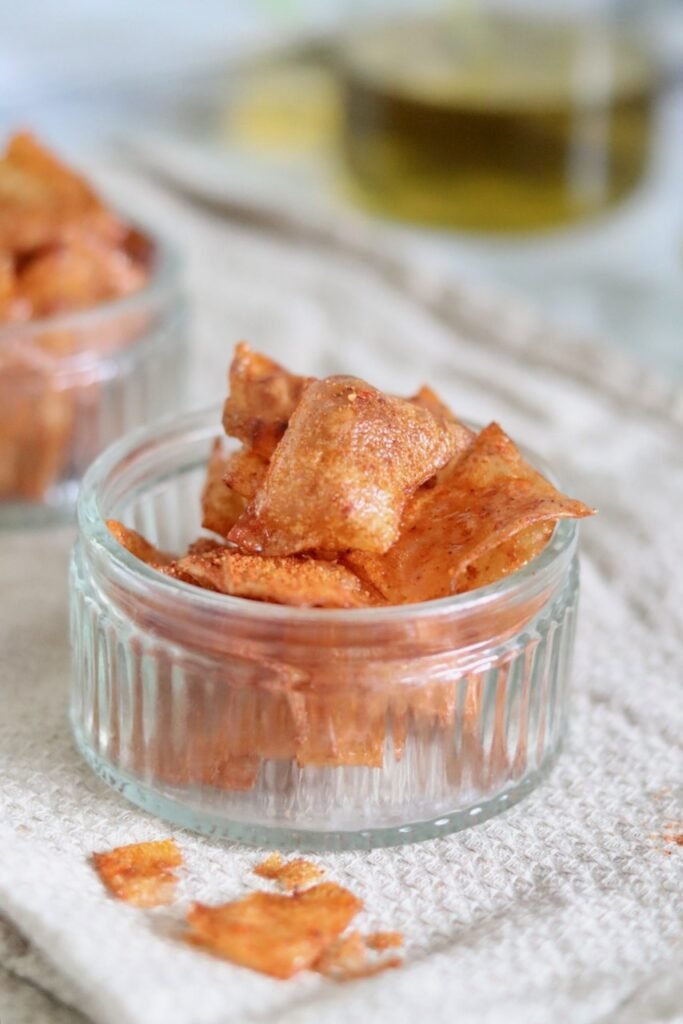Bowl of crispy BBQ rice paper chips with a bottle of olive oil behind