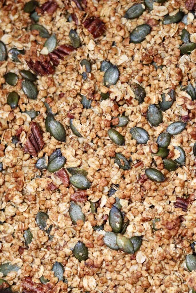Close up of crunchy pumpkin granola clusters with pecans and pumpkin seeds