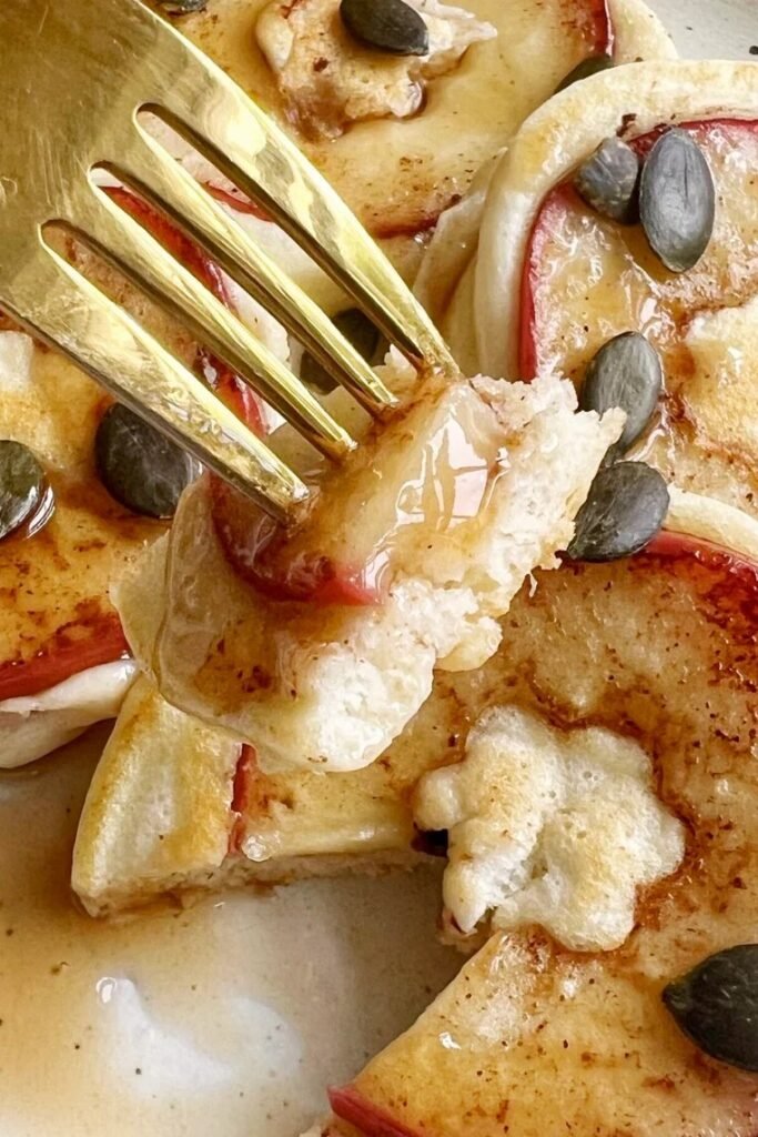 Spiced apple pancakes with pumpkin seeds and a gold fork