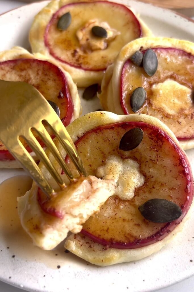 Fork lifting a piece of spiced apple pancake to show the fluffy inside