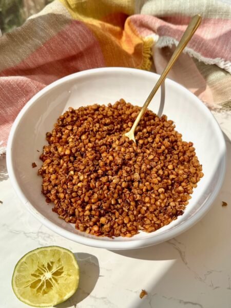 Air fryer crispy lentils in a white bowl with a gold spoon and a squeezed lime