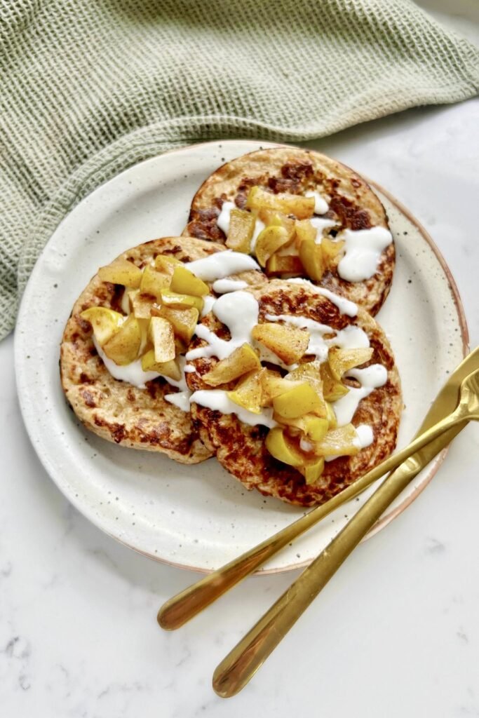 Three apple pie cottage cheese pancakes topped with spiced apples and Greek yogurt