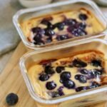 Two glass dishes of blueberry baked yogurt soufflé with fresh blueberries