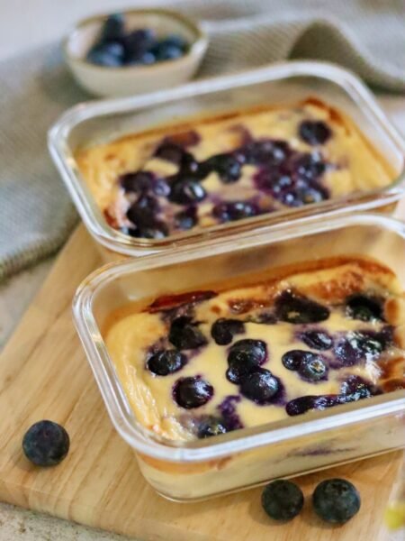 Two glass dishes of blueberry baked yogurt soufflé with fresh blueberries