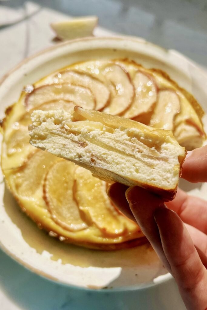 Close up of a slice of gluten free apple cake showing the soft, custardy almond crumb