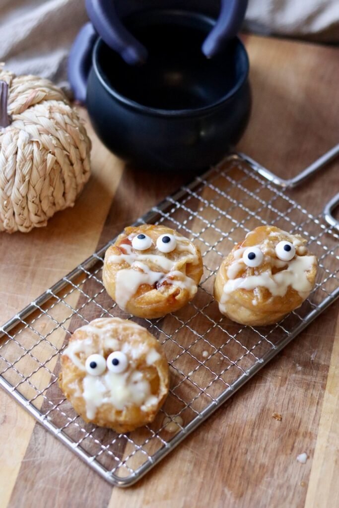Three Halloween pumpkin rice paper muffins on a cooling rack