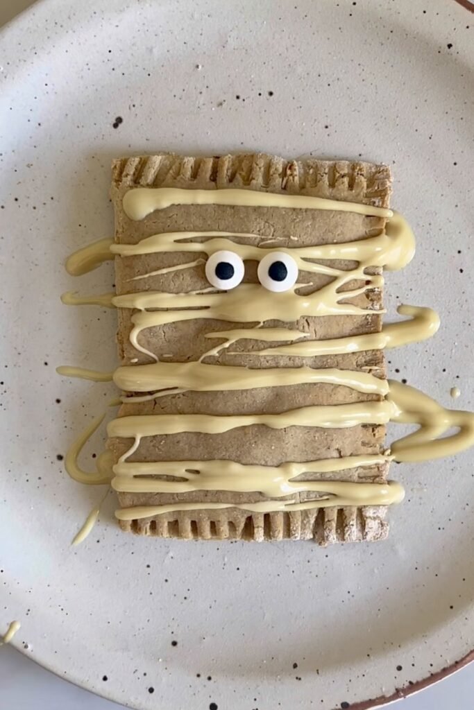 Top down view of a homemade vegan pumpkin pop tart with white chocolate drizzle