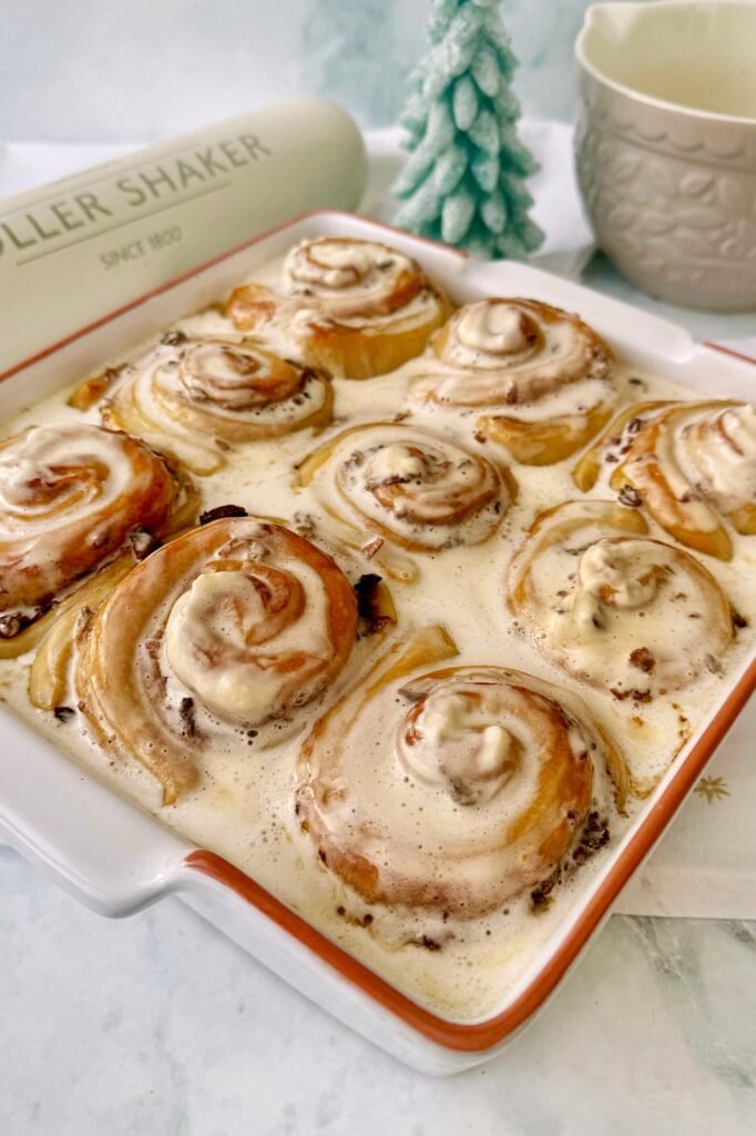 Tray of mince pie cinnamon rolls topped with brandy cream
