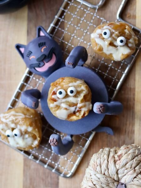 Overhead Halloween spread of pumpkin rice paper muffins decorated as mummies