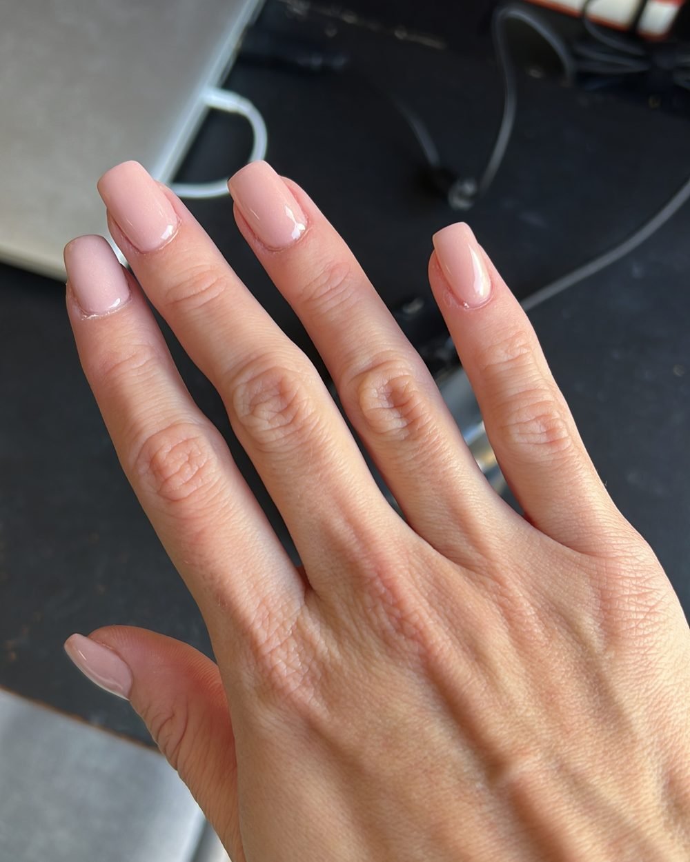 Soft pink nude Manucurist Green nail polish on short square nails