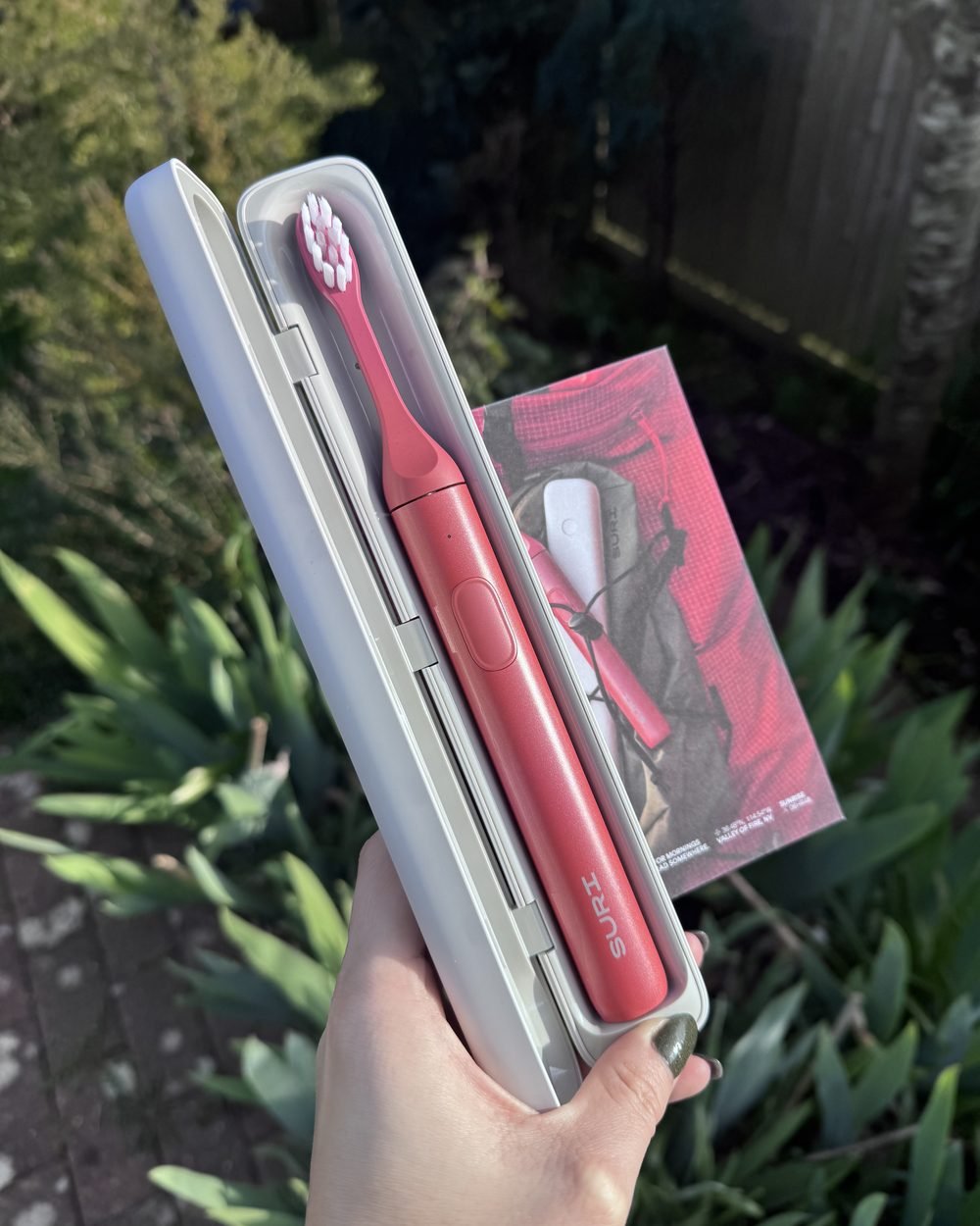 SURI electric toothbrush in its travel case