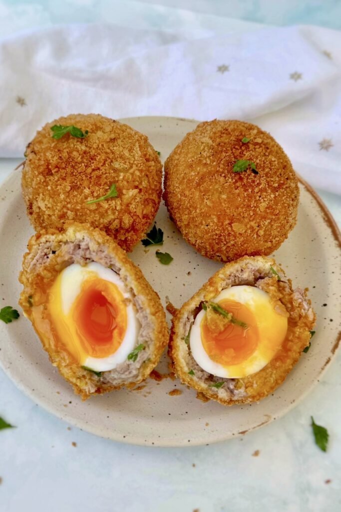 Turkey and pork scotch eggs cut open to show jammy soft boiled yolks